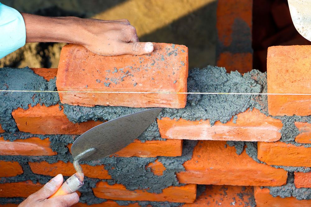 Maçon posant des briques avec du mortier